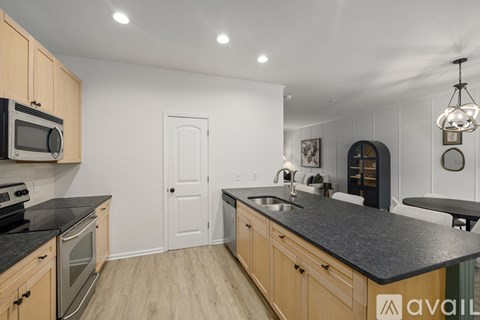 A kitchen with wooden cabinets and black countertops.