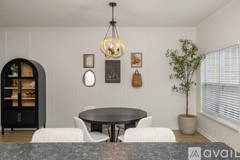 A dining room with a round table and chairs.