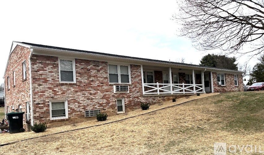 A brick house with a white fence in front.