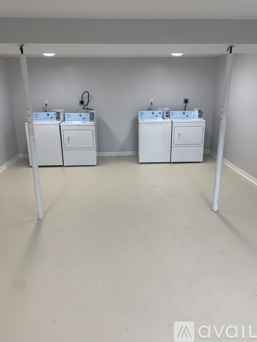 Two white washing machines in a room.