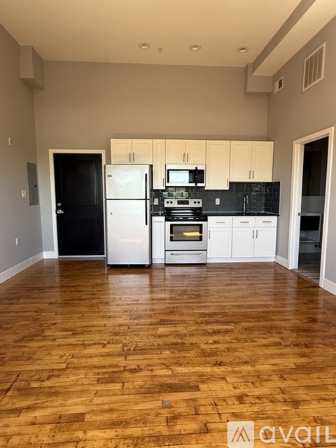 A kitchen with black countertops and white cabinets.