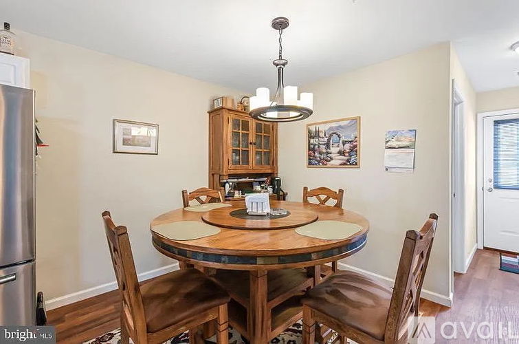 A dining room with a wooden table and chairs.