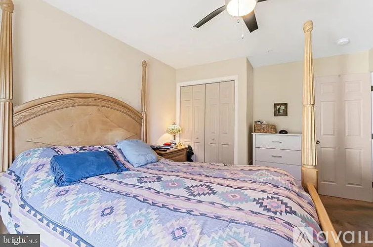 A bedroom with a large bed and a ceiling fan.