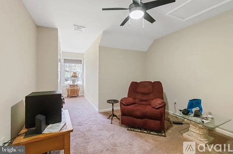 A living room with a red chair and a television.