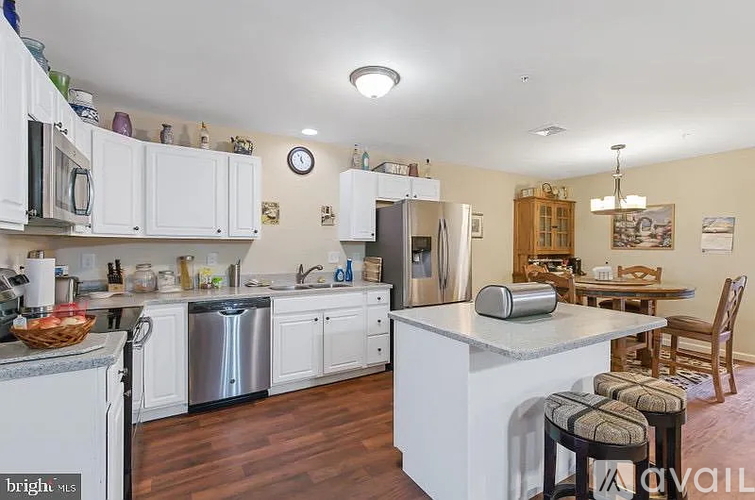 A kitchen with white cabinets and a wooden table.