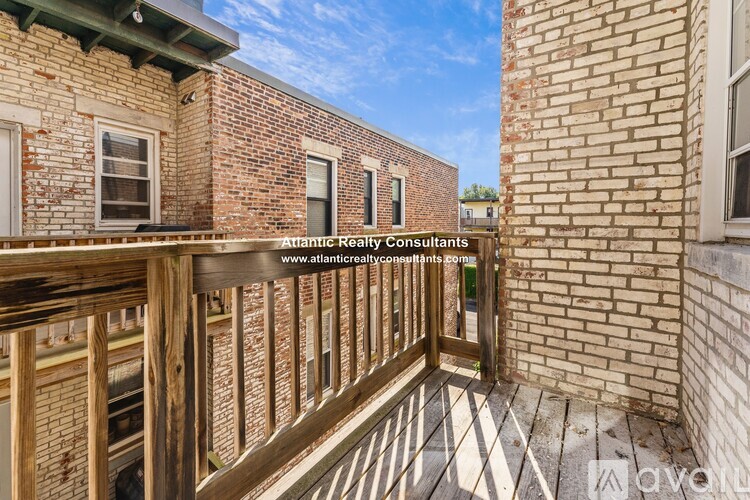A balcony with a wooden railing and brick buildings.