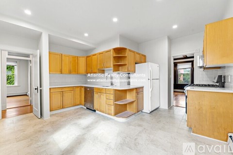 A modern kitchen with wooden cabinets and a white refrigerator.