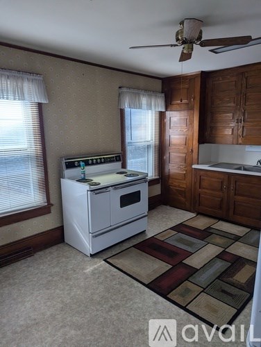 A kitchen with a white oven and a ceiling fan.