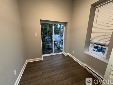 A room with a sliding glass door leading to a balcony.