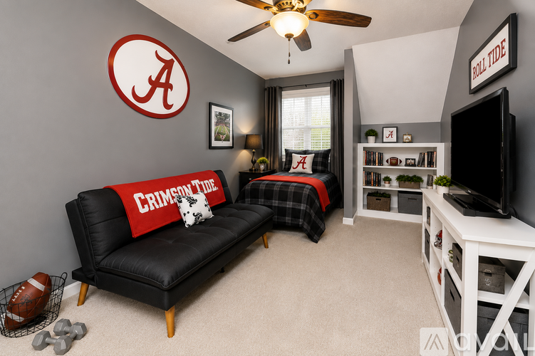 A living room with a black couch and a football on the floor.