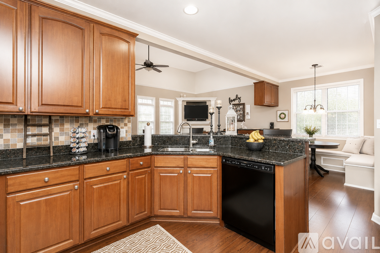 A kitchen with wooden cabinets and black appliances.
