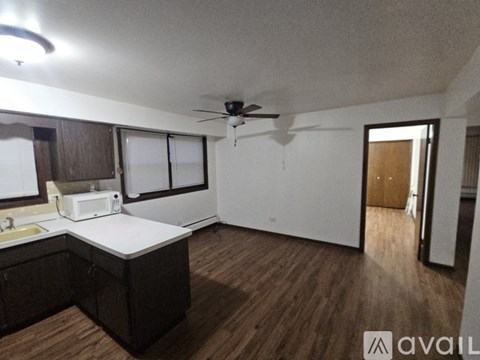A kitchen with a white countertop and wooden cabinets.