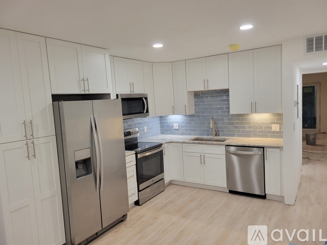 A kitchen with white cabinets and stainless steel appliances.