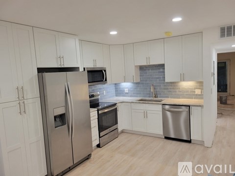 A kitchen with white cabinets and stainless steel appliances.
