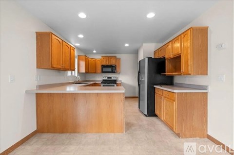 A kitchen with wooden cabinets and appliances.