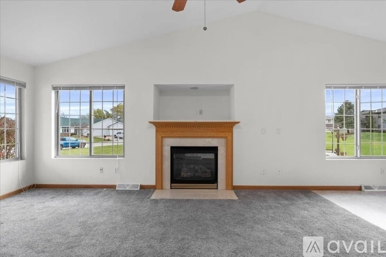 A living room with a fireplace and a large window.