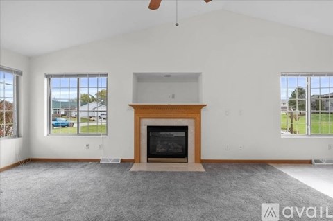 A living room with a fireplace and a large window.
