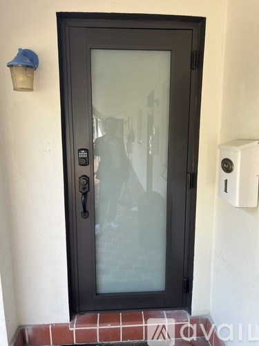 A black door with a glass window and a black handle.