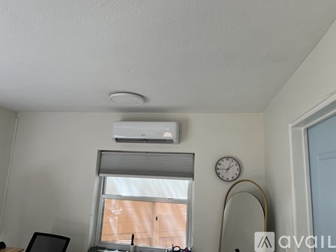 A room with a clock and an air conditioner.