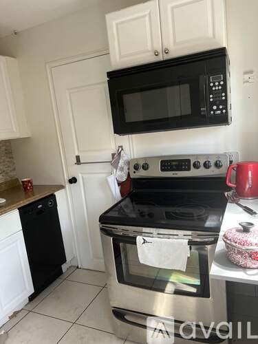 A kitchen with a black microwave mounted above a stove.