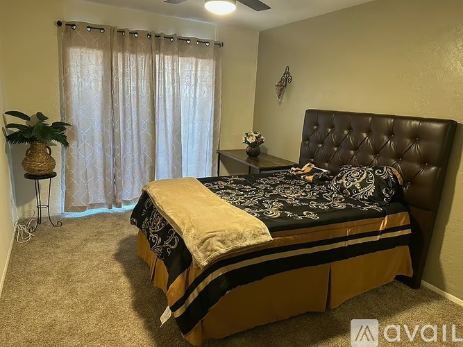A bedroom with a black bed and a pineapple on a small table.