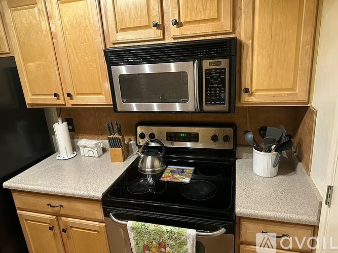 A kitchen with wooden cabinets and a black stove top.