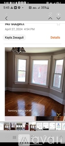 A room with wooden flooring and three windows.