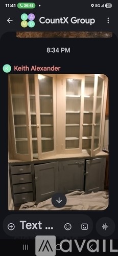 A white cabinet with glass doors is open and appears to be in the process of being installed or repaired.