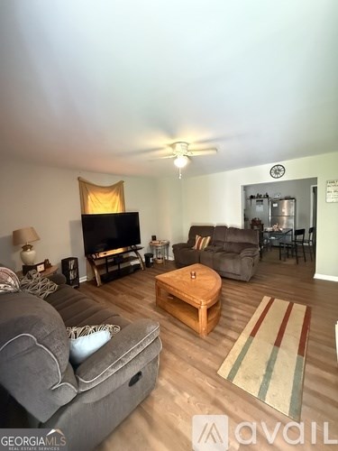 A living room with a grey couch, a wooden coffee table, and a television.