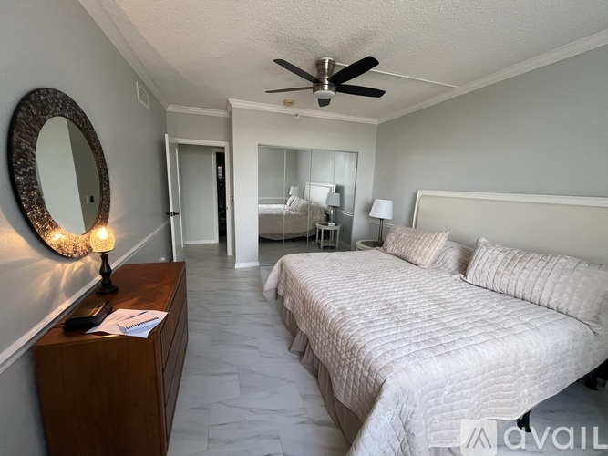A bedroom with a large bed and a ceiling fan.