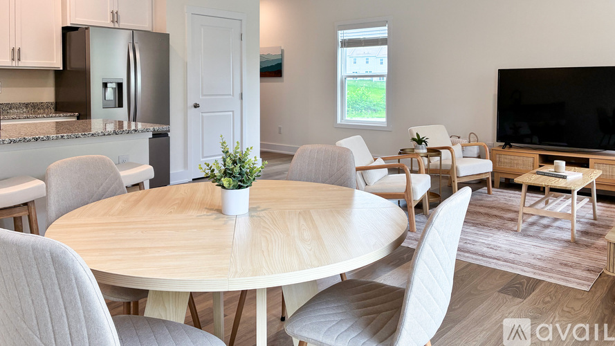 A modern dining room with a round table and chairs.