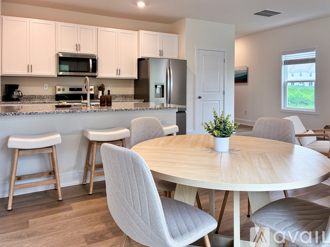 A kitchen with a table and chairs.