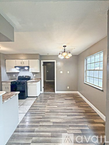 A kitchen with a tile floor leading to a hallway.