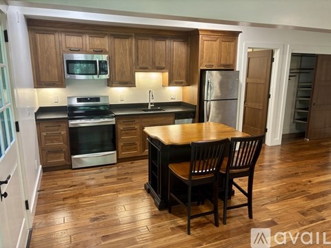 A kitchen with wooden cabinets and a black countertop.