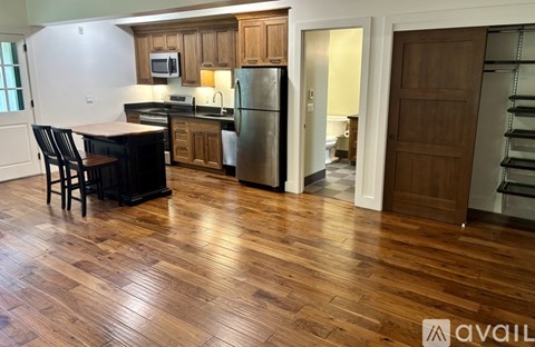 A kitchen with wooden floors and a refrigerator.