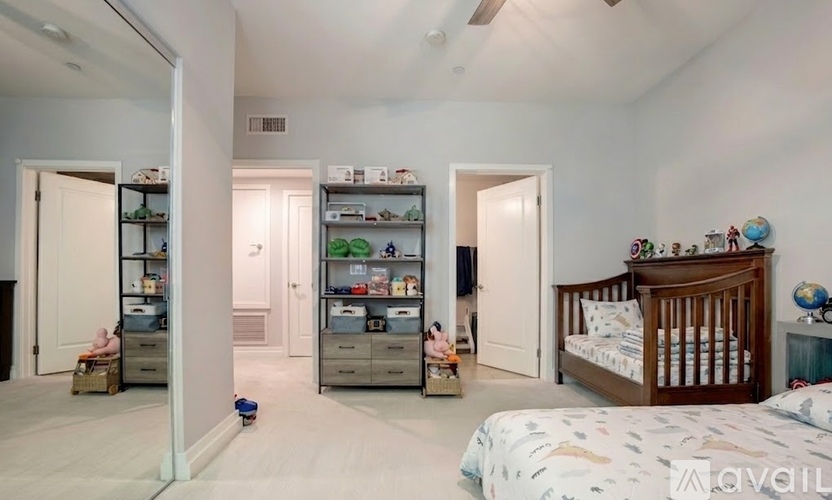 A bedroom with a white bed and a white ceiling fan.