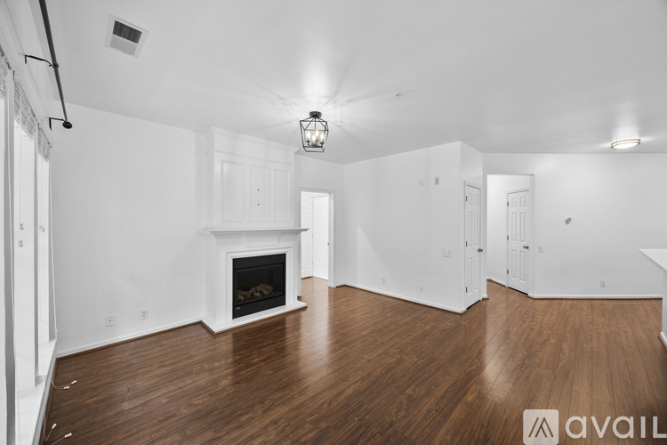 A spacious living room with a fireplace and wooden floors.