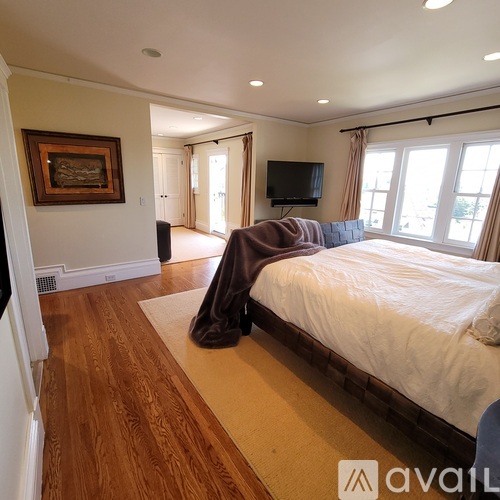 A bedroom with a large bed and a television.