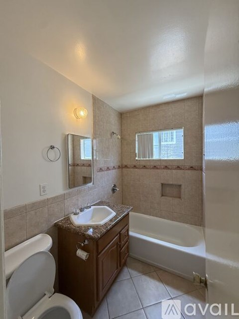 A bathroom with a toilet, sink, and bathtub.