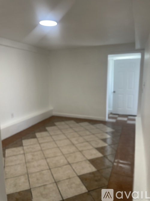 A room with a checkered floor and a door in the background.