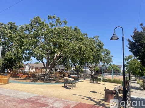 A park with a playground and picnic tables.