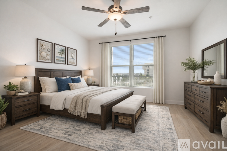 A bedroom with a large bed, a bench, and a ceiling fan.