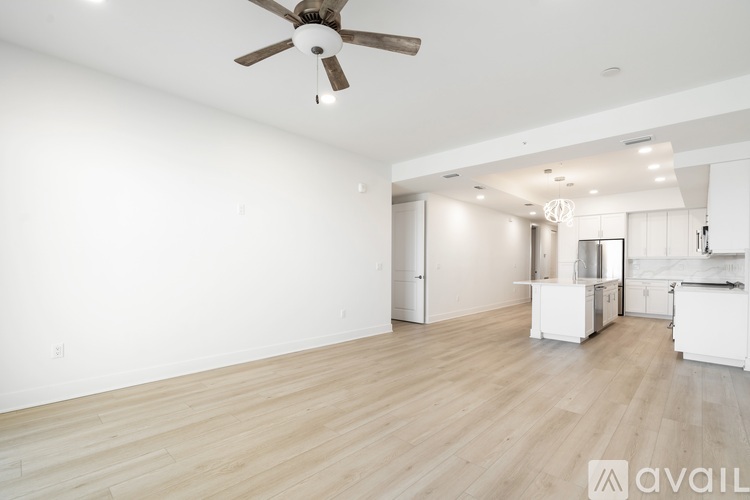 A spacious room with a ceiling fan and lighting fixtures.