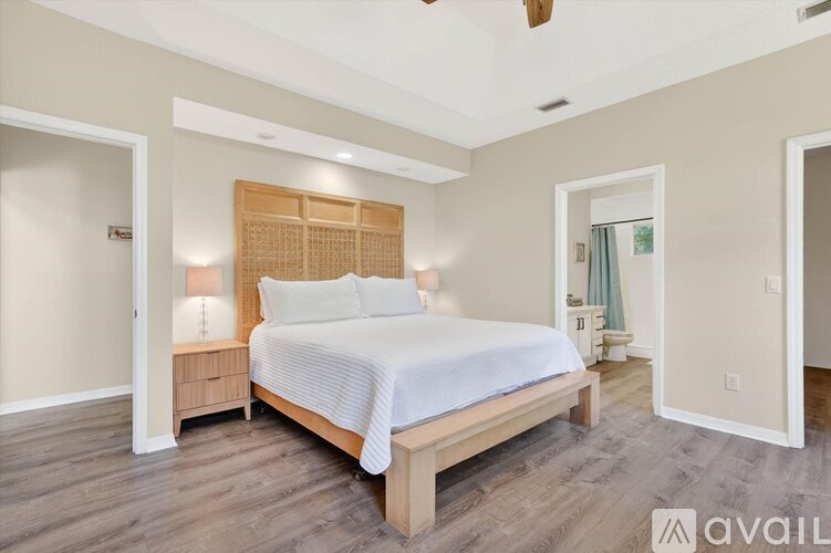A bedroom with a large bed and a wooden headboard.