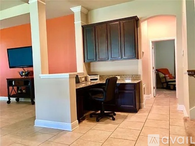 A kitchen with a black chair and a black oven.