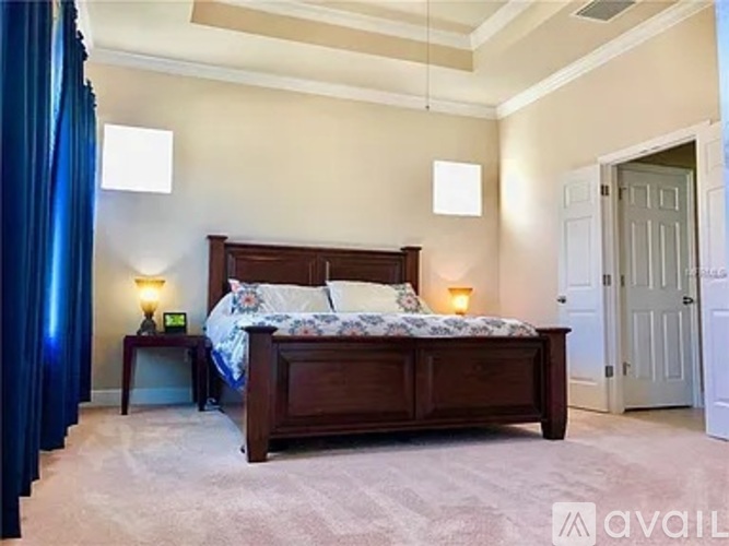 A bedroom with a large bed and a blue curtain on the left.