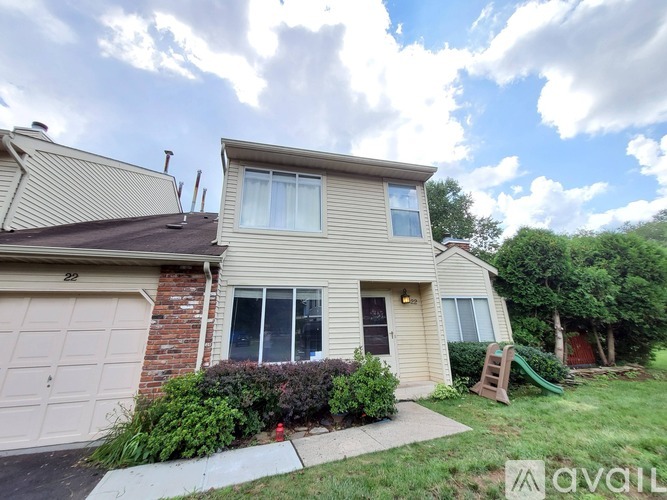 A two-story house with a garage and a small garden.