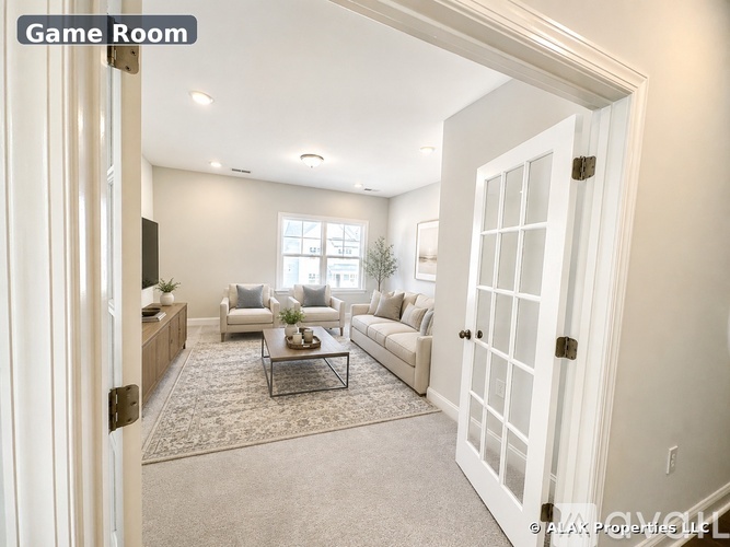A well-lit game room with a couch, chairs, and a coffee table.