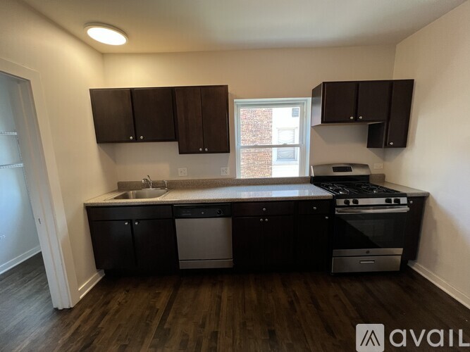 A kitchen with black cabinets and a stove top oven.