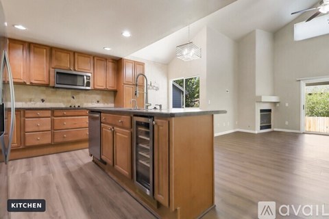 A kitchen with wooden cabinets and a stainless steel refrigerator.